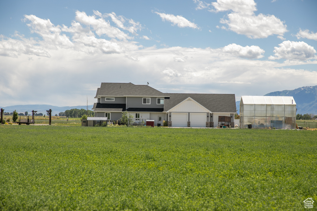 Rear view of house featuring a lawn and a mountain view