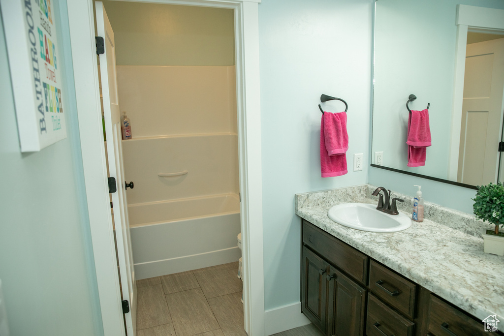 Bathroom featuring tile patterned flooring, shower / washtub combination, and vanity