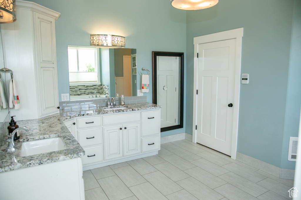 Bathroom featuring a shower with door, vanity, and tile patterned floors