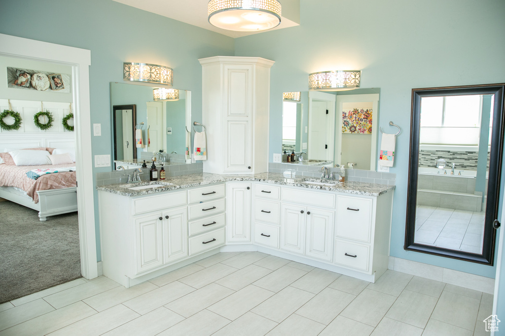 Bathroom featuring tile patterned floors and double sink vanity