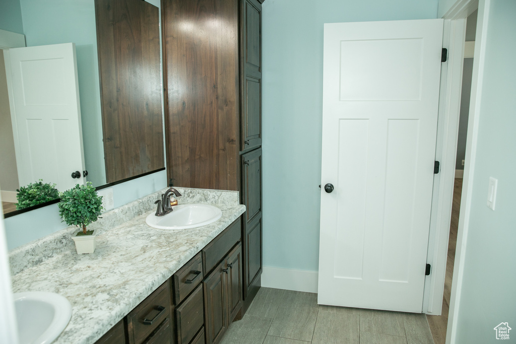 Bathroom with tile patterned flooring and dual bowl vanity