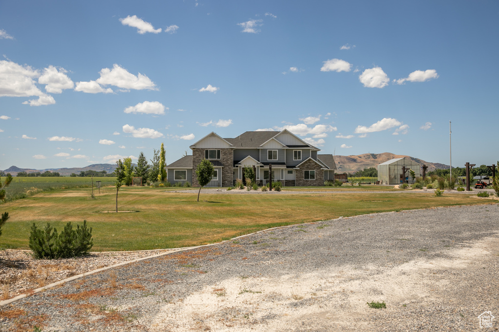 View of front facade featuring a mountain view and a front yard