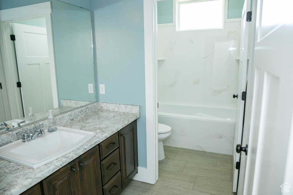 Full bathroom with bathtub / shower combination, vanity, tile patterned flooring, and toilet