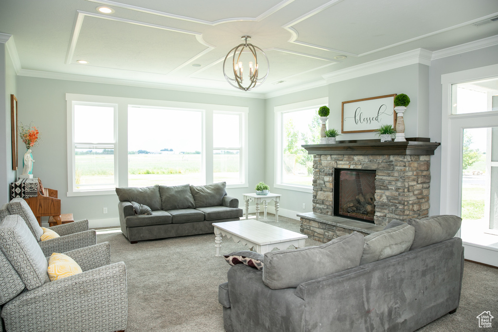 Living room with ornamental molding, an inviting chandelier, carpet, and a fireplace