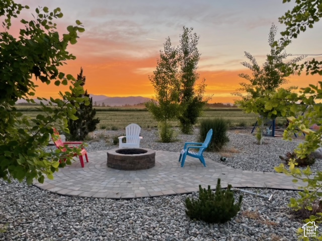 Patio terrace at dusk with a mountain view and an outdoor fire pit