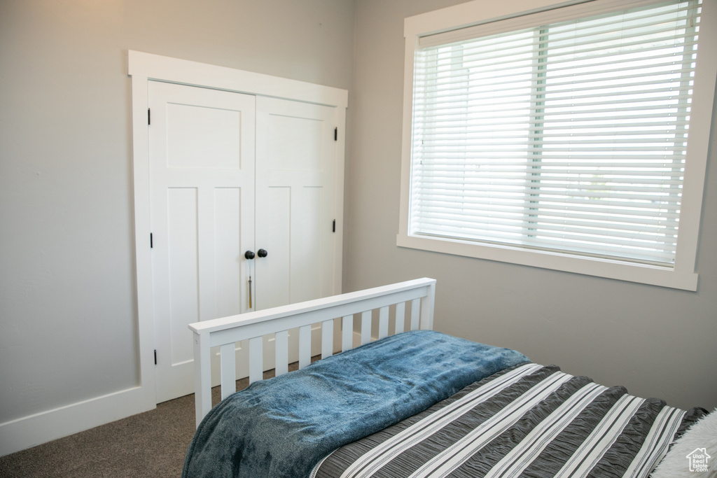 Bedroom featuring dark carpet and a closet