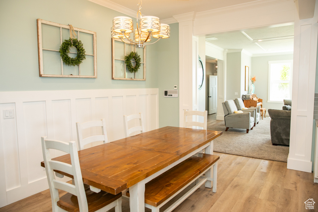 Dining space featuring an inviting chandelier, hardwood / wood-style flooring, and ornamental molding