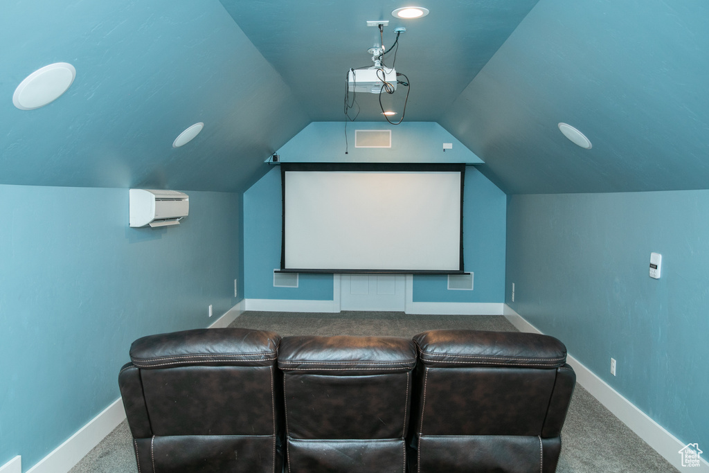 Carpeted home theater with a wall unit AC and vaulted ceiling