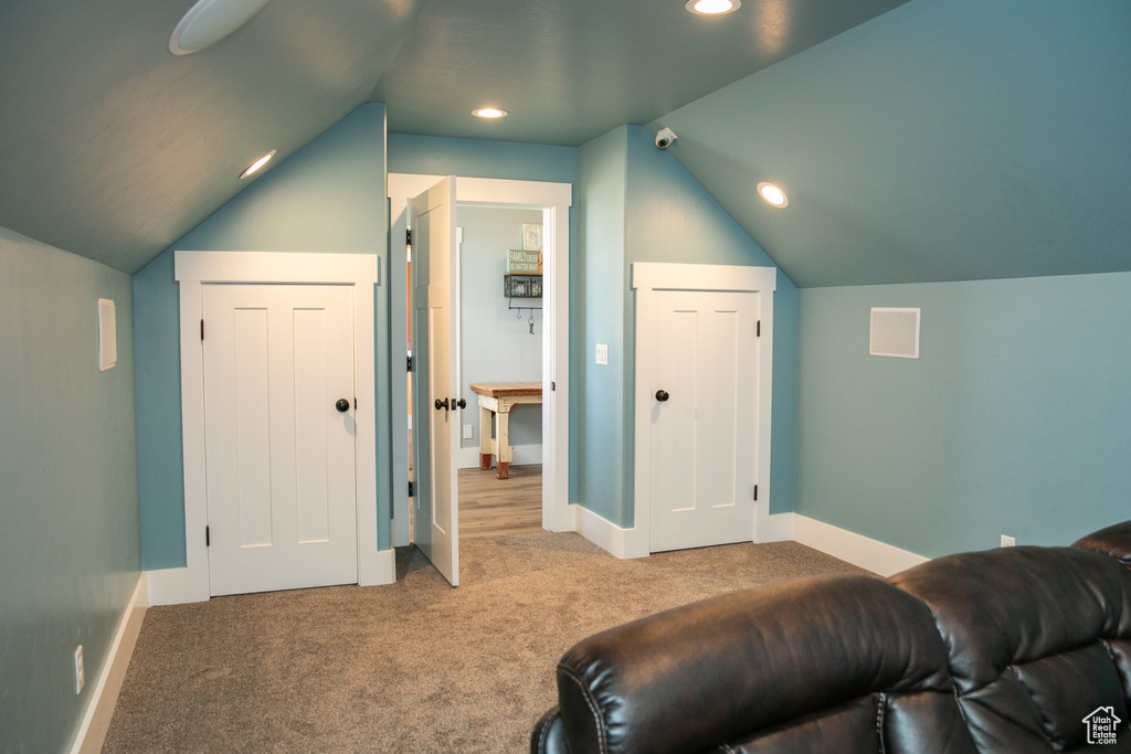 Carpeted cinema room featuring lofted ceiling