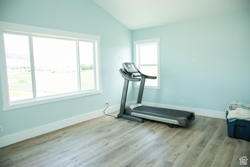 Exercise room featuring hardwood / wood-style flooring and lofted ceiling