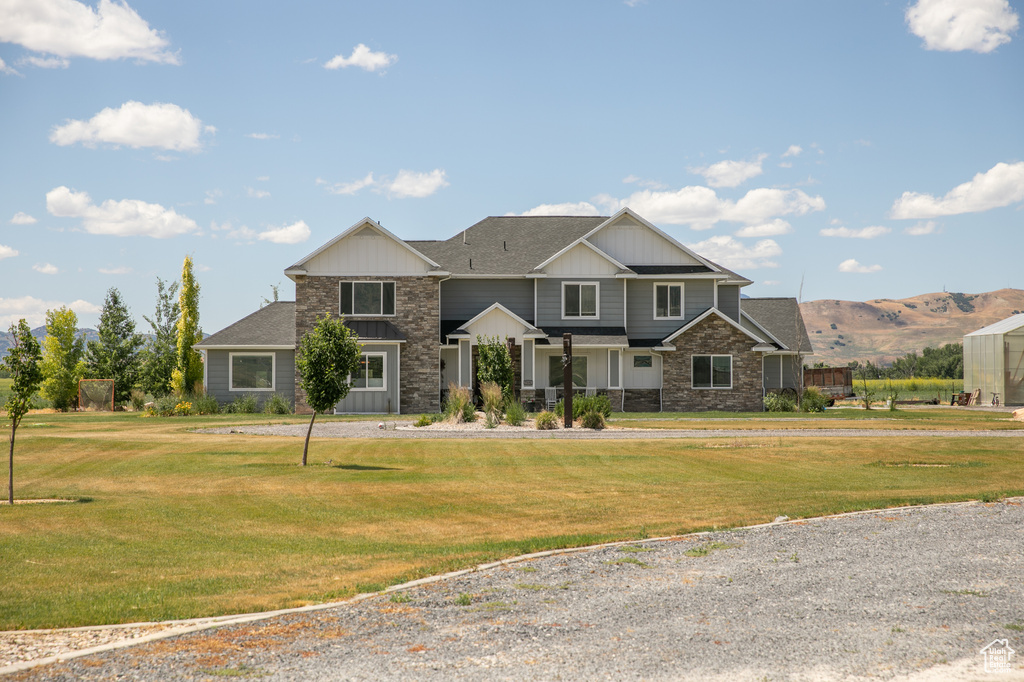 View of front of property featuring a mountain view and a front yard