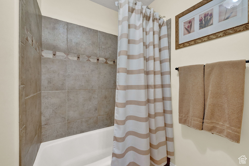 Bathroom featuring shower / tub combo with curtain