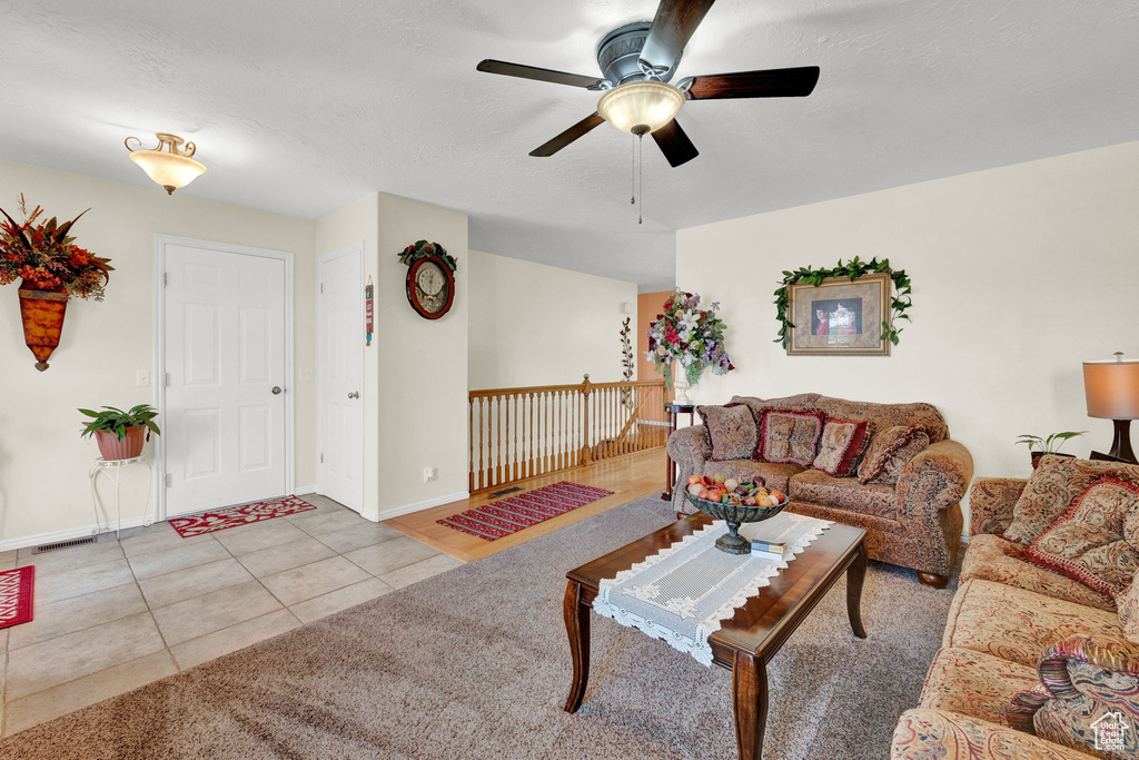 Living room featuring light tile patterned flooring and ceiling fan