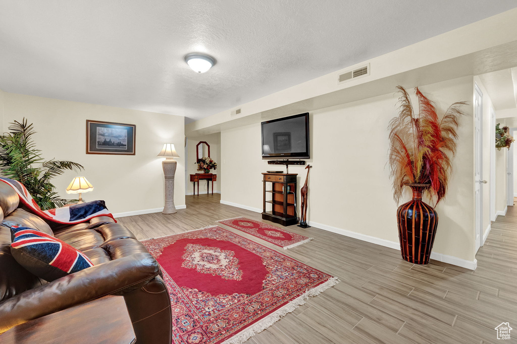 Living room featuring a textured ceiling and hardwood / wood-style floors