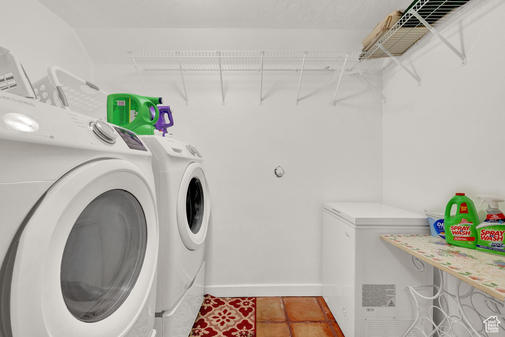 Laundry room with washing machine and clothes dryer and tile patterned flooring