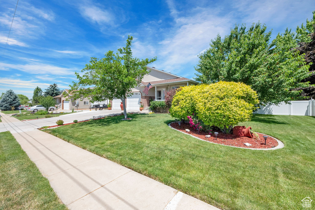 View of front of house featuring a garage and a front lawn