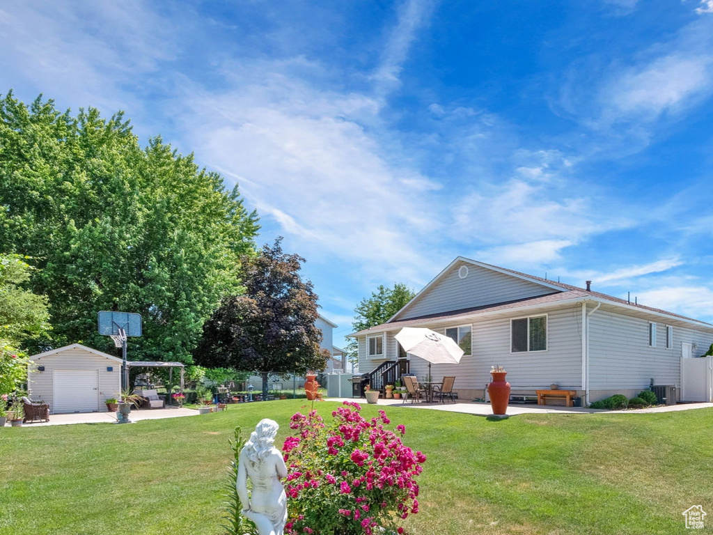 View of yard with a garage and an outbuilding