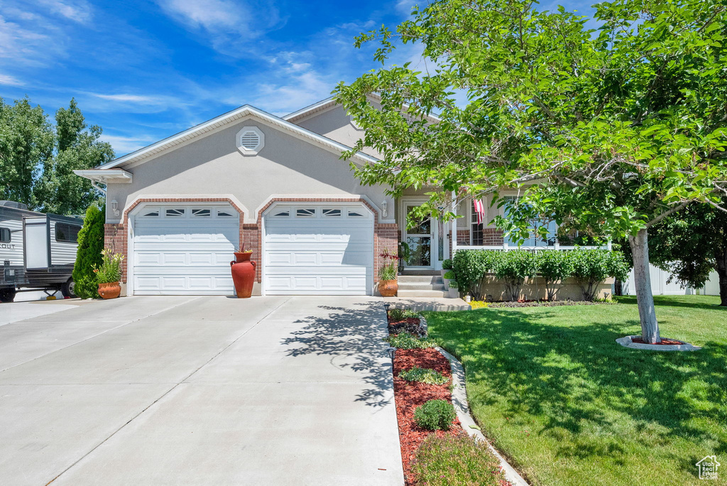 View of front of property featuring a garage and a front lawn