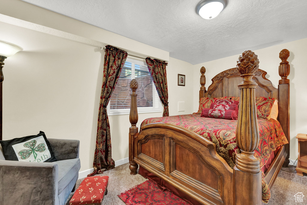 Bedroom featuring carpet floors and a textured ceiling