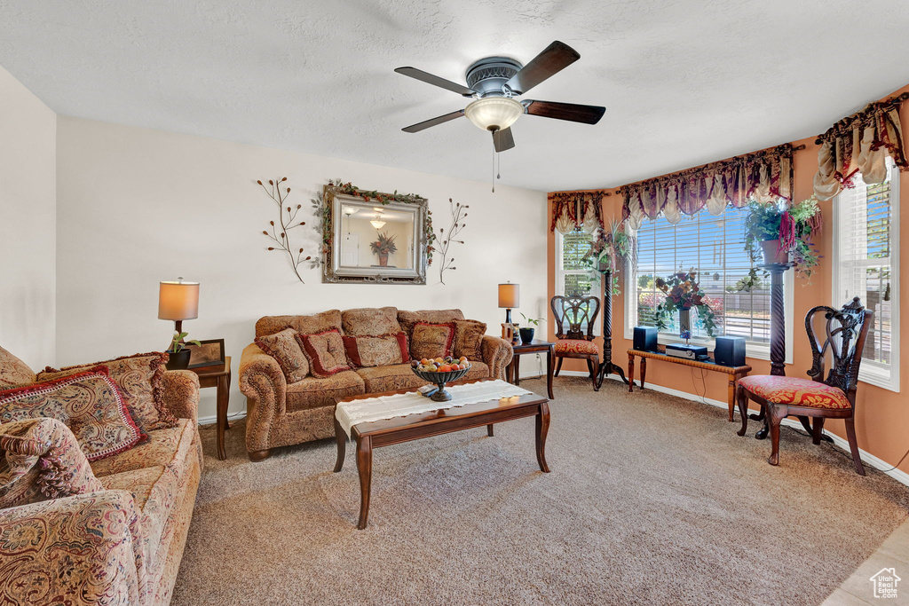 Carpeted living room featuring ceiling fan