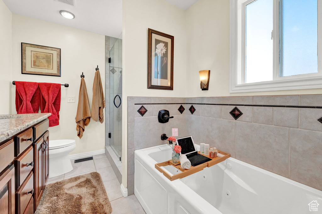 Full bathroom with tile patterned floors, plus walk in shower, toilet, and vanity