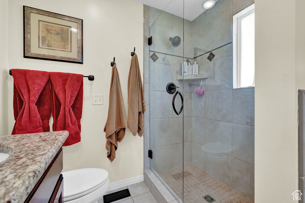 Bathroom with walk in shower, a wealth of natural light, toilet, and vanity