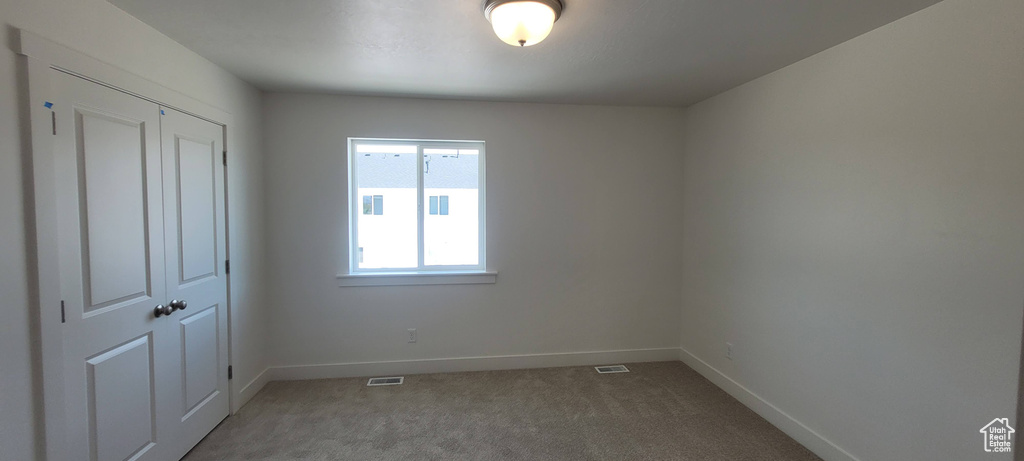 Unfurnished bedroom with a closet and carpet floors