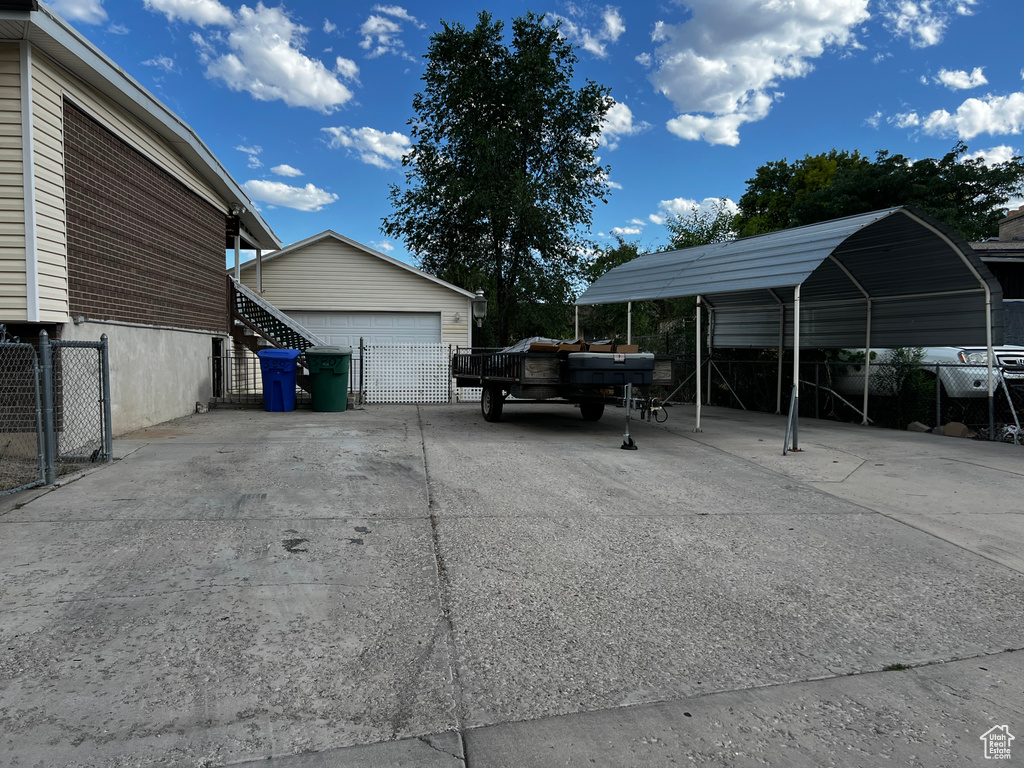 View of vehicle parking featuring a garage and a carport