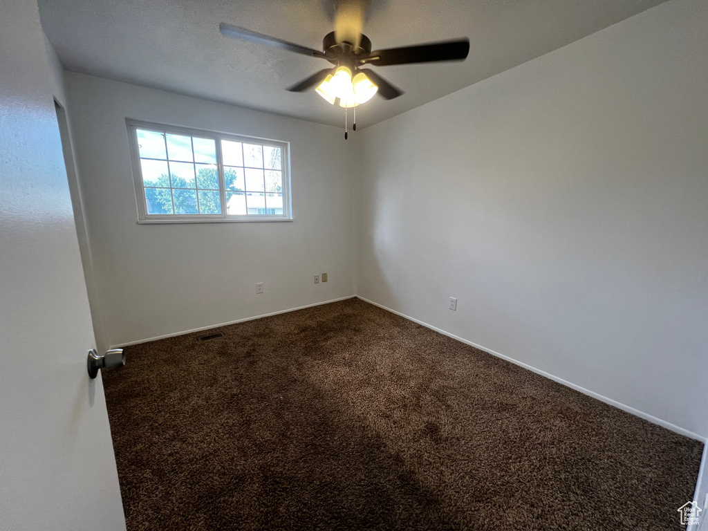 Carpeted empty room with ceiling fan