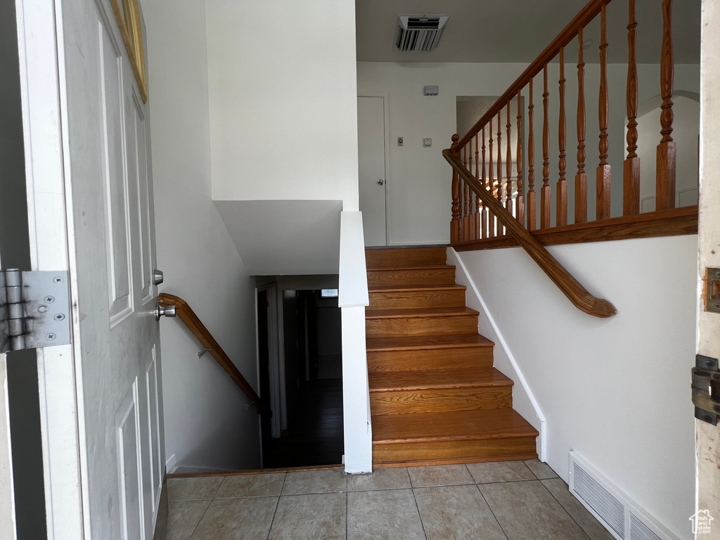 Stairs featuring light tile patterned floors