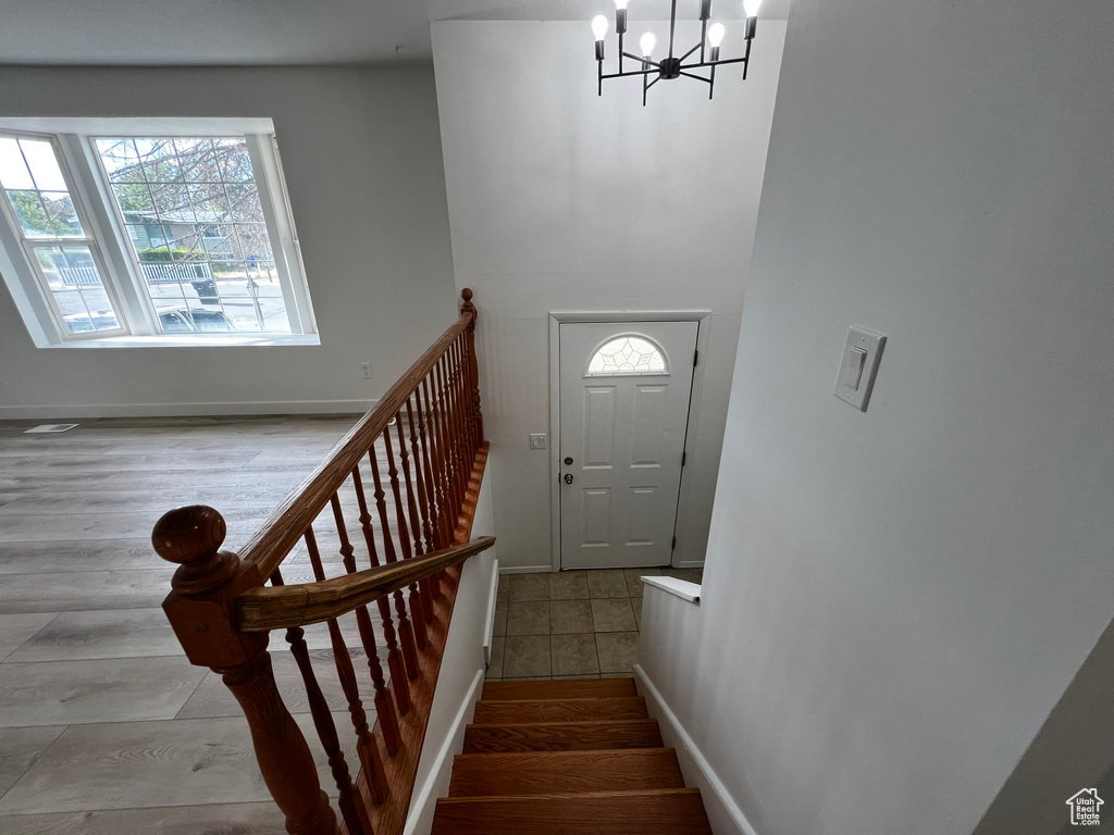 Stairs with a notable chandelier and hardwood / wood-style floors