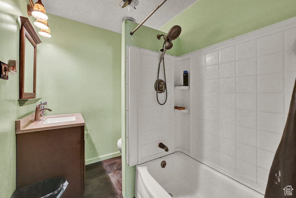 Full bathroom with shower / tub combo, toilet, vanity, and a textured ceiling