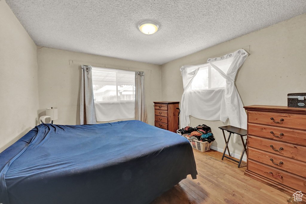 Bedroom featuring a textured ceiling and light hardwood / wood-style floors