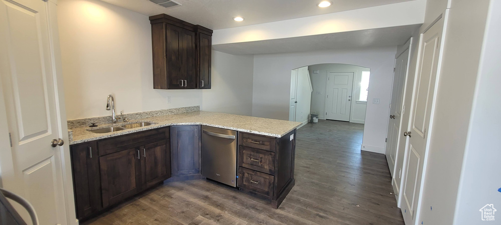 Kitchen with hardwood / wood-style floors, sink, light stone counters, dark brown cabinetry, and dishwasher