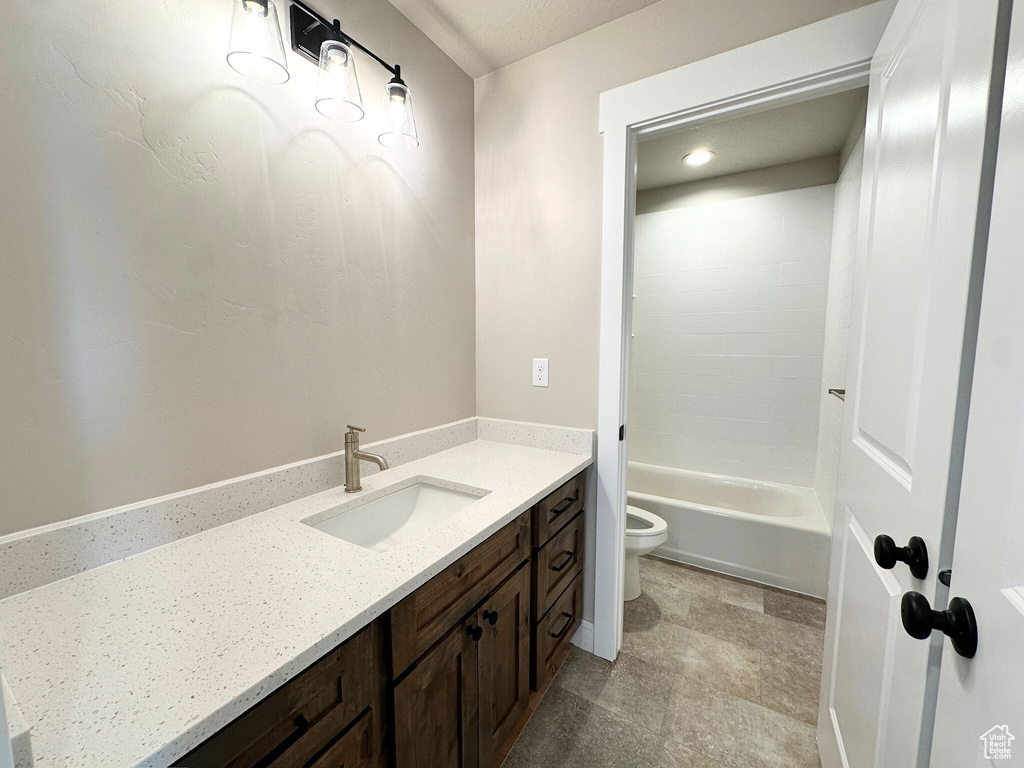 Full bathroom with washtub / shower combination, toilet, and vanity