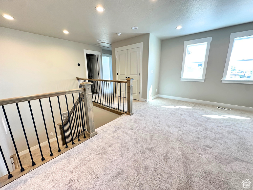 Interior space featuring light carpet and a textured ceiling