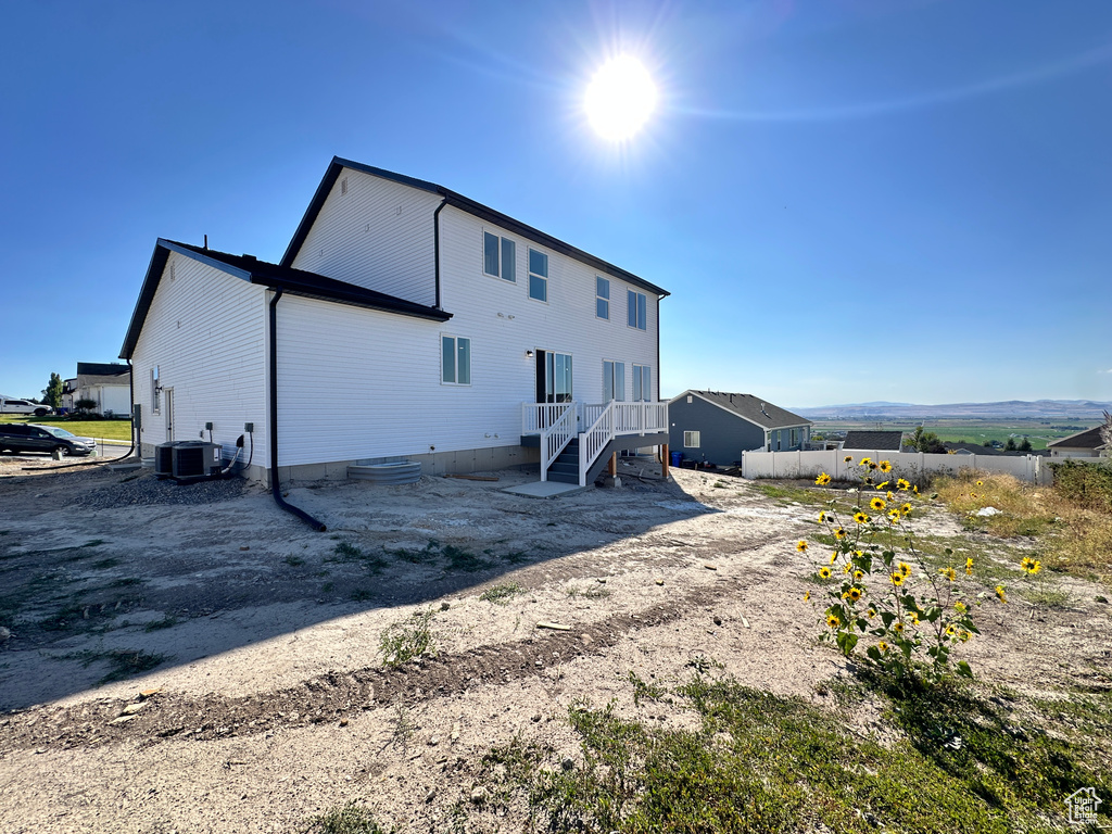 Back of house with central AC unit