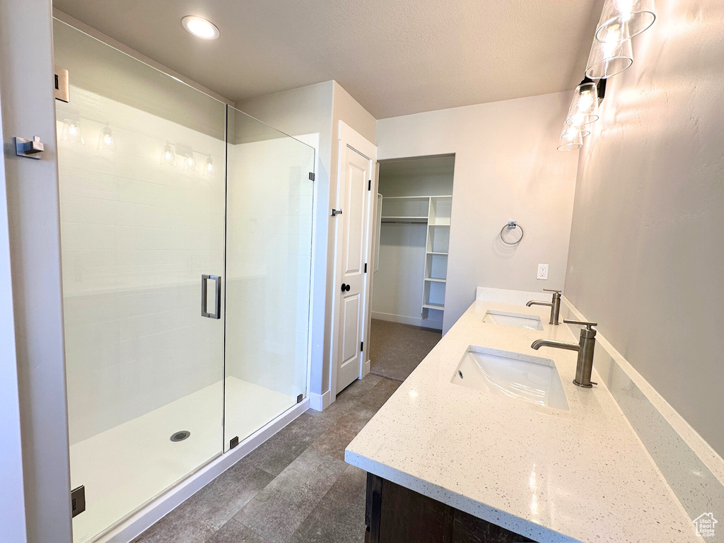 Bathroom featuring vanity and a shower with door