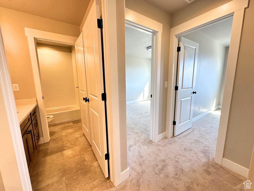 Hall with light carpet and a textured ceiling