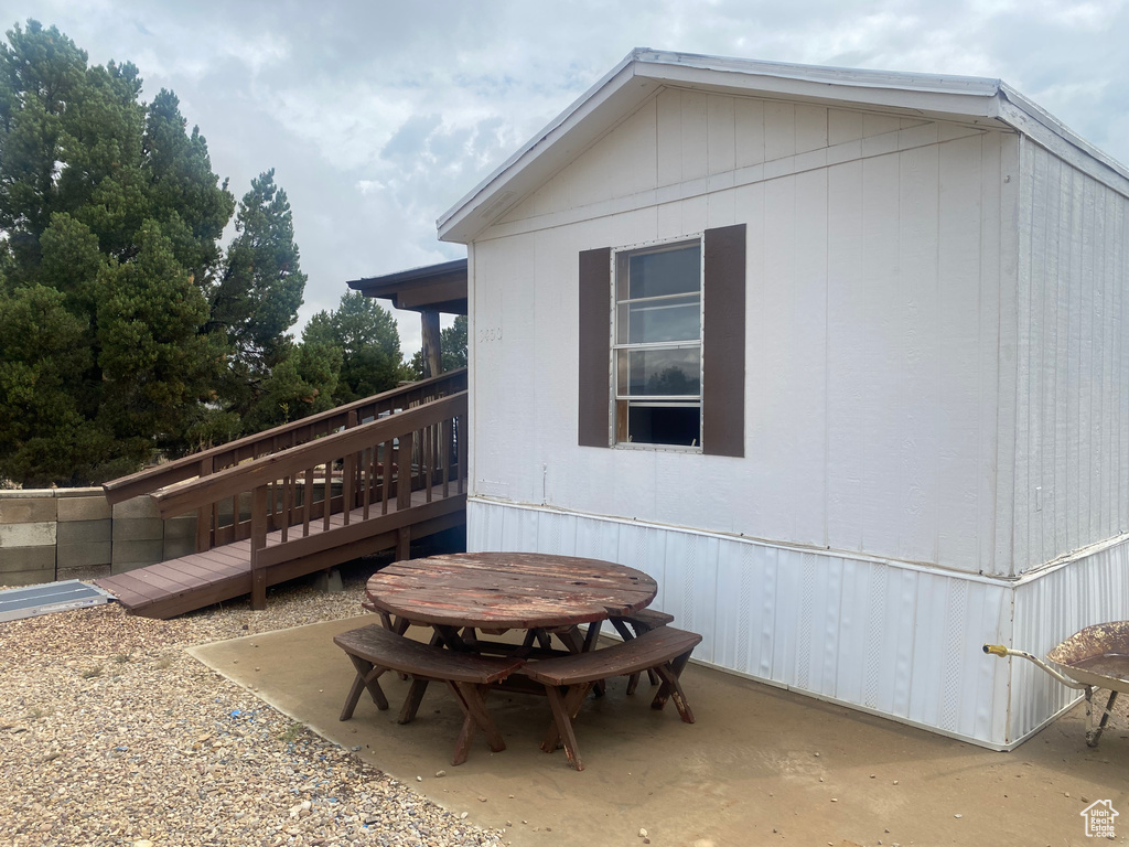 View of side of home featuring a deck and a patio area