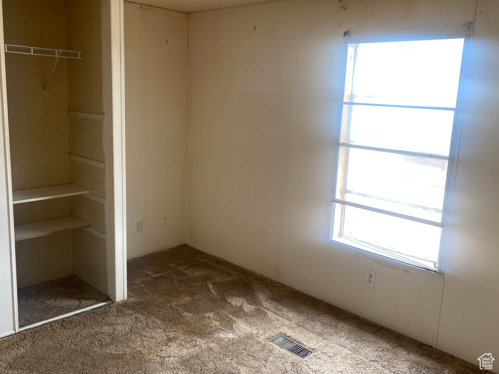 Interior space with dark carpet and a closet