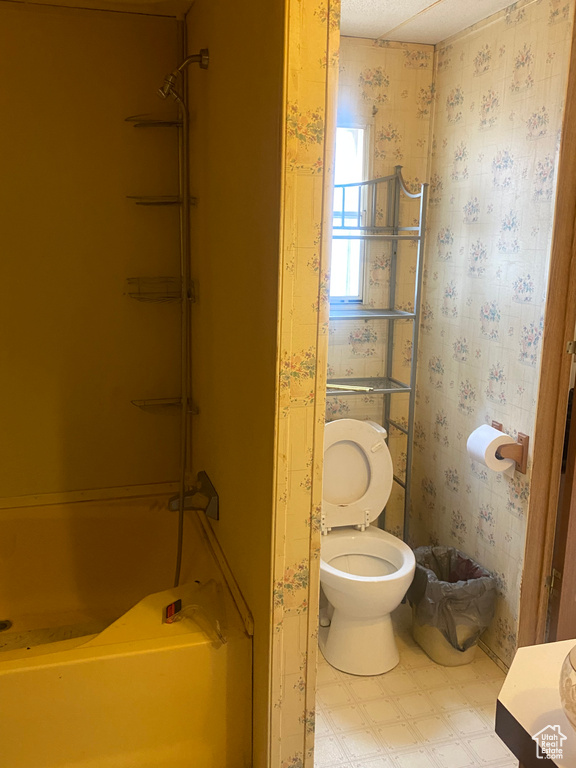 Bathroom featuring shower / bath combination, tile patterned flooring, and toilet