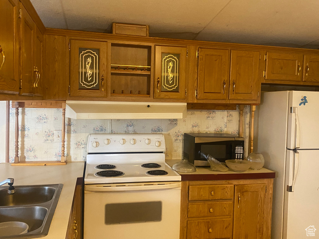 Kitchen featuring white appliances and sink