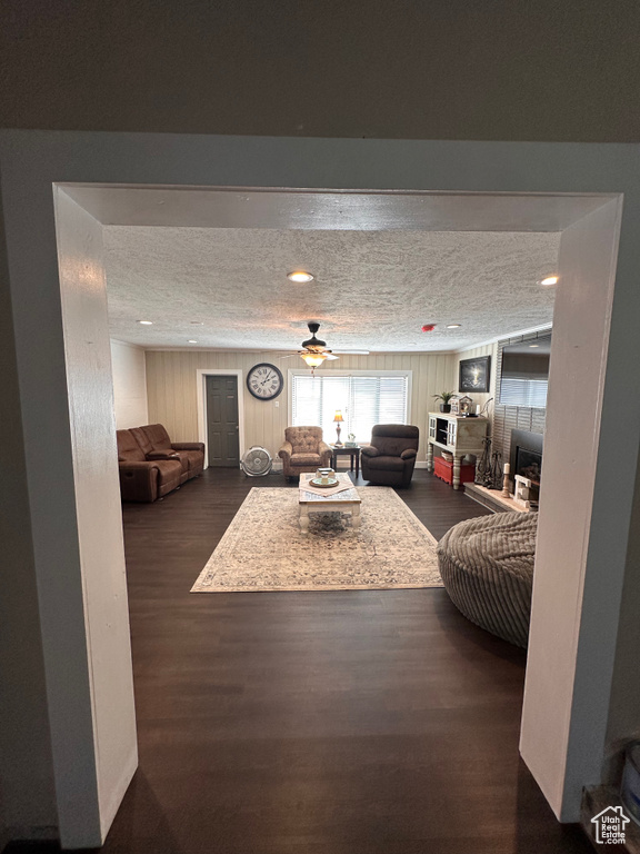 Living room with a fireplace, a textured ceiling, and dark hardwood / wood-style floors