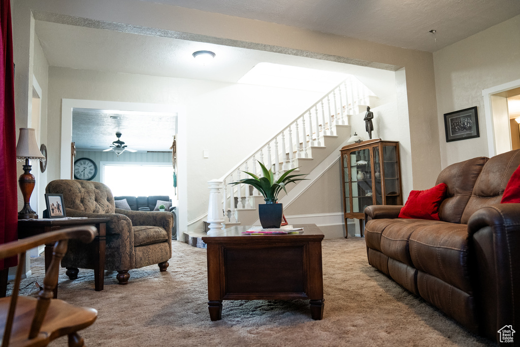 Carpeted living room with ceiling fan