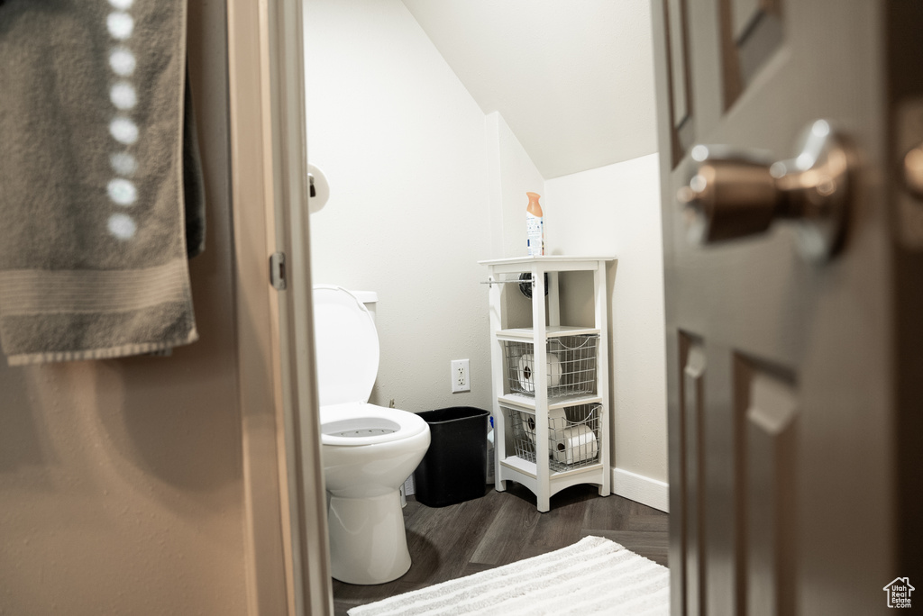 Bathroom with hardwood / wood-style floors, lofted ceiling, and toilet