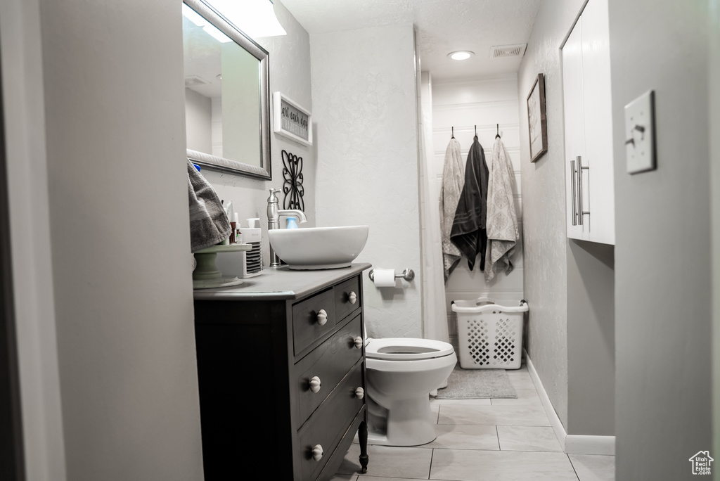 Bathroom featuring tile patterned floors, vanity, and toilet