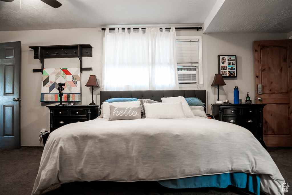 Bedroom with dark carpet and ceiling fan