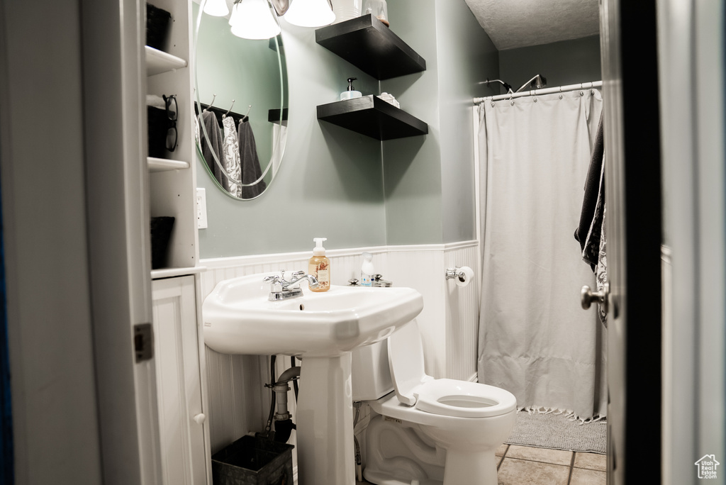 Bathroom featuring toilet, a textured ceiling, and tile patterned flooring