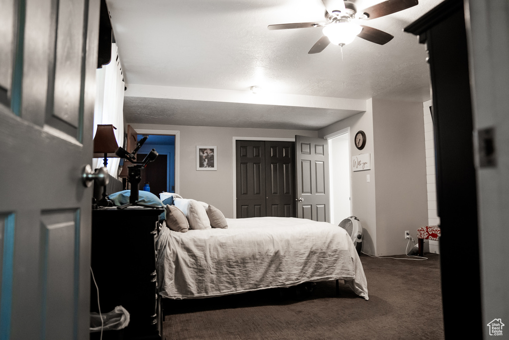 Bedroom with carpet floors, a textured ceiling, and ceiling fan